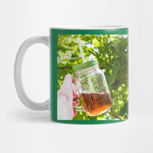 Hand holding a glass mug of cold tea Mug